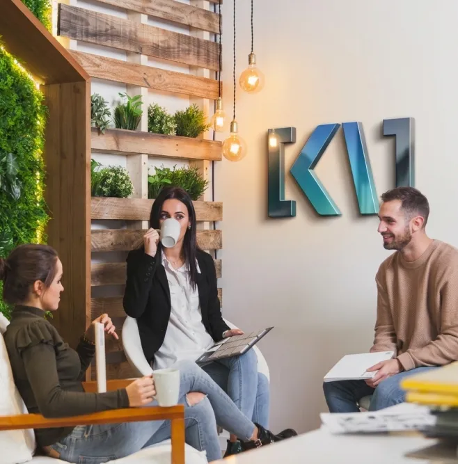 Photo d'un groupe de 3 personnes dans les locaux de Keywer, discutant autour d'un café